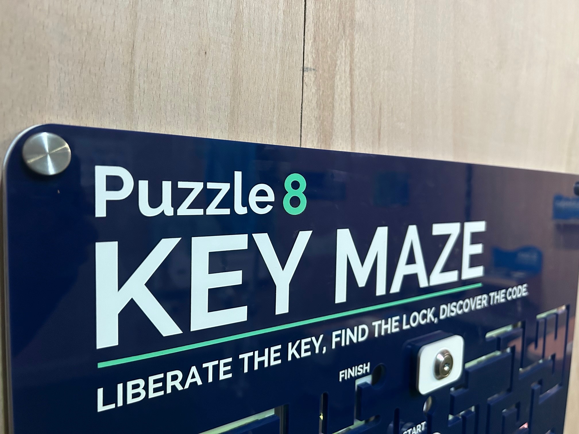 A blue sign on a wall that says Puzzle 8, Key Maze, Liberate the Key, Find the Lock, Discover the Code