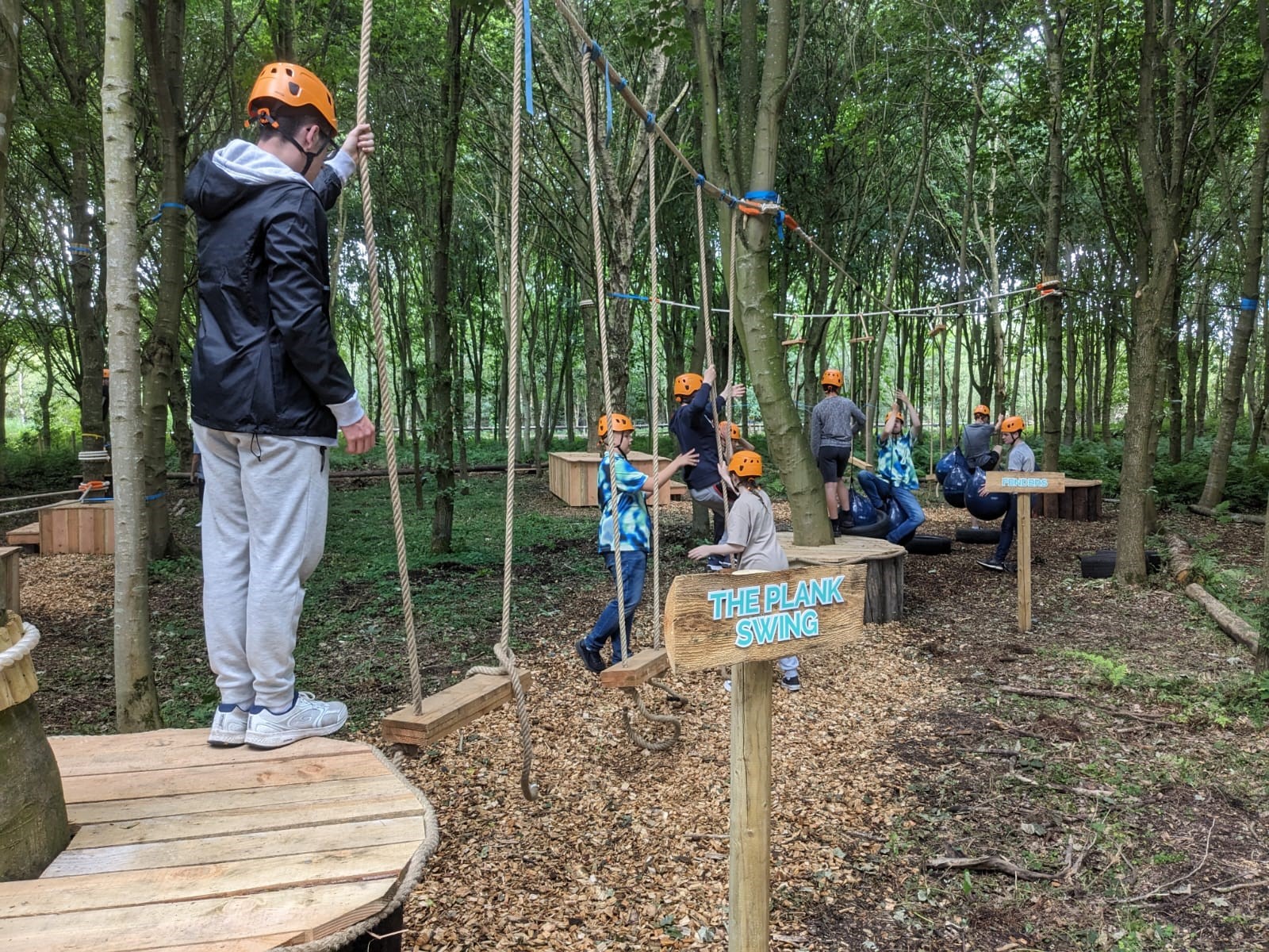 Young people taking on the low ropes course in the adventure wood at north Yorkshire water park