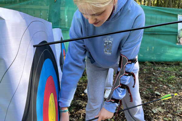 A young person removes an arrow from brightly coloured target in a woodland in North Yorkshire