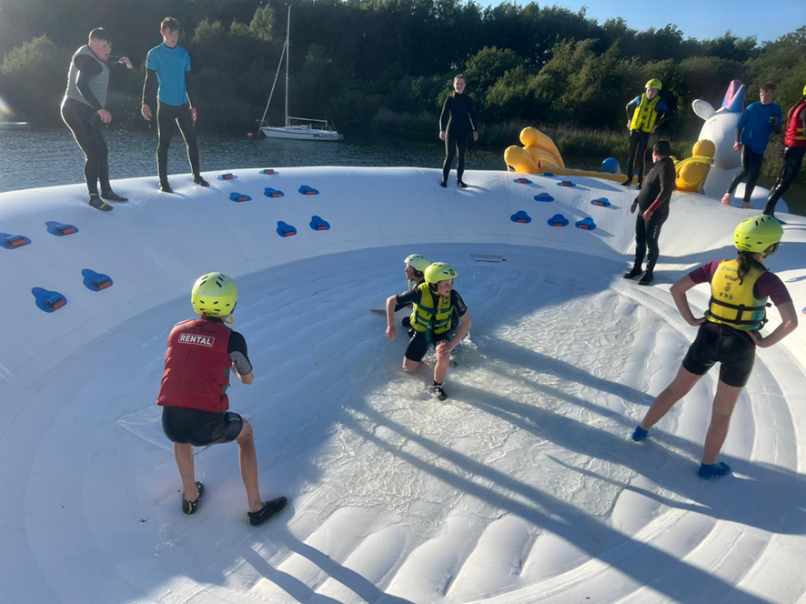 People on top of an inflatable unicorn playing in the water at the unicorn splash park