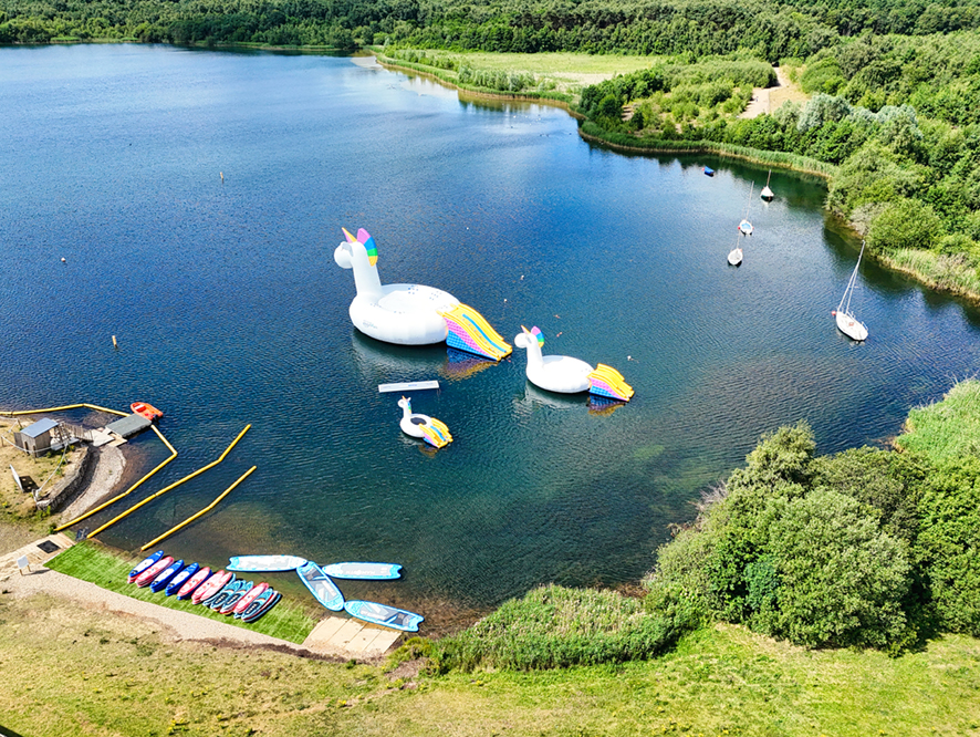 Inflatable Unicorn family floating on a lake with boats at NYWP