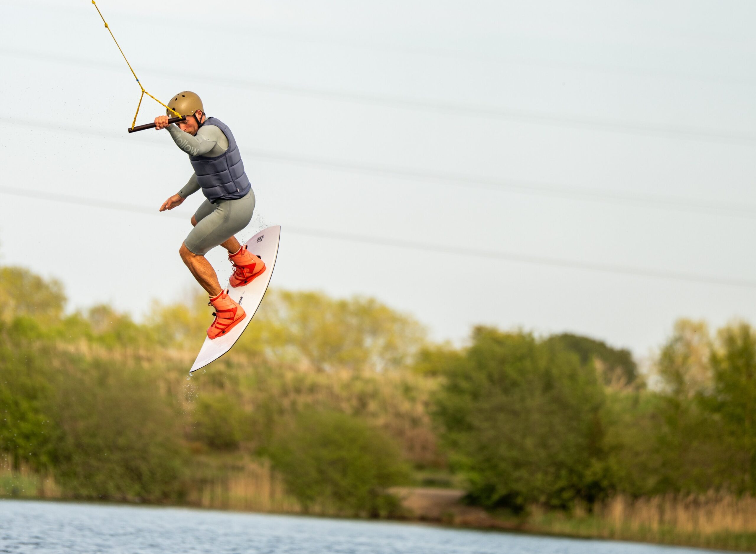 A man, in mid air, takes part in wakeboarding across a lake in North Yorkshire