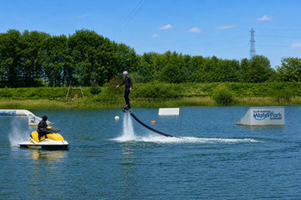 Flyboarding and jetski on lake at north yorkshire water park with big kicker ramp in the background